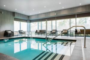 - une grande piscine dans un bâtiment doté de fenêtres dans l'établissement AC Hotel by Marriott Boston Cambridge, à Cambridge