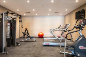 um ginásio com passadeiras e equipamento de exercício numa sala em Protea Hotel by Marriott Owerri Select em Owerri