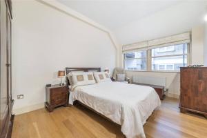 a white bedroom with a bed and a window at Luxurious serviced apt next to the City of London and Tower Bridge in London