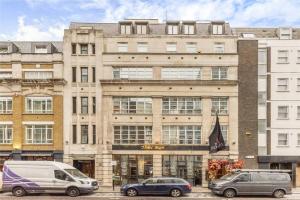 two cars parked in front of a large building at Luxurious serviced apt next to the City of London and Tower Bridge in London