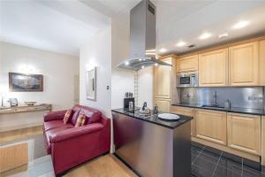 een keuken met een rode stoel naast een aanrecht bij Luxurious serviced apt next to the City of London and Tower Bridge in Londen