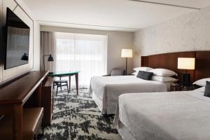 a hotel room with two beds and a desk at Sheraton Vancouver Airport Hotel in Richmond +35 photos
