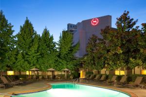 a swimming pool in front of a building with a clock at Sheraton Vancouver Airport Hotel in Richmond