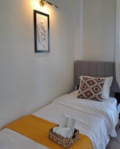 Una cama con dos toallas y una cesta. en FG Home Rental, en Xanthi