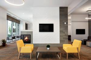 a living room with yellow chairs and a fireplace at Residence Inn by Marriott San Jose Cupertino in Cupertino