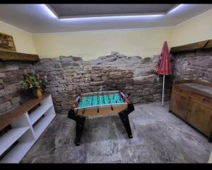 a room with a table in front of a stone wall at Gîte Dubois in Romanswiller