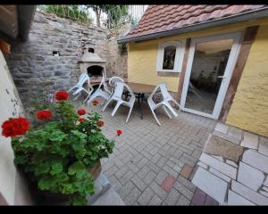 patio ze stołem, krzesłami i kwiatami w obiekcie Gîte Dubois w mieście Romanswiller
