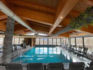 una gran piscina con sillas en un edificio en Hotel Yara en Vişeu de Sus