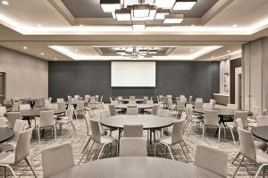 una sala de conferencias con mesas, sillas y una pizarra en AC Hotel by Marriott St Louis Chesterfield, en Chesterfield