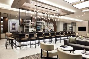un vestíbulo con un bar con sillas y mesas en AC Hotel by Marriott St Louis Chesterfield, en Chesterfield