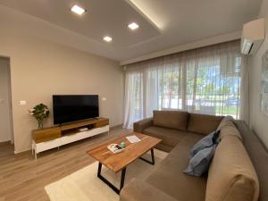 a living room with a couch and a flat screen tv at Sunshine Homes Zamárdi in Zamárdi