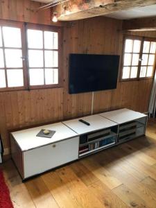 a living room with a flat screen tv on a wall at Romantisches Plätzchen in der Natur in Grindelwald