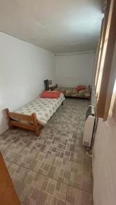a bedroom with a bed and a tiled floor at Carpe Diem in Las Heras