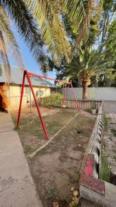 a swing set in a yard next to a bench at Carpe Diem in Las Heras