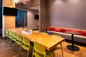 SpringHill Suites by Marriott Pittsburgh North Shore في بيتسبرغ: قاعة اجتماعات مع طاولة خشبية وكراسي صفراء