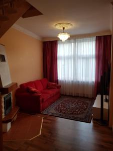 een woonkamer met een rode bank voor een raam bij Apartman Moravska 188 in Karlsbad