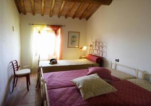 um quarto com 2 camas, uma cadeira e uma janela em Schönes Ferienhaus in Gambassi Terme mit Privatem Pool em Gambassi Terme