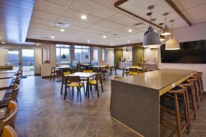 a restaurant with tables and chairs and a bar at Fairfield Inn & Suites by Marriott Flint Grand Blanc in Grand Blanc