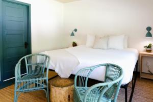 a bedroom with a bed and two chairs at Piety Hill Cottages in Nevada City
