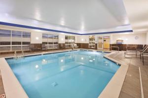 Fairfield Inn & Suites by Marriott Flint Grand Blanc في غراند بلانك: مسبح كبير مع ماء أزرق في غرفة الفندق