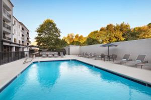 a swimming pool with chairs and umbrellas on a building at Courtyard by Marriott Burlington in Burlington