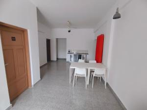 a dining room with a white table and white chairs at Retaj Residency in Ernakulam