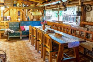 a dining room with a long wooden table and chairs at Chalupa u Žofky in Oščadnica