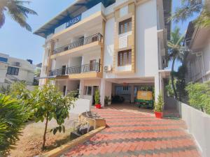 a large white building with a red brick driveway at Retaj Residency in Ernakulam