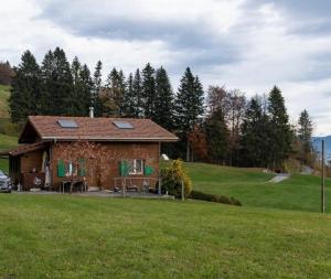 una pequeña casa en una colina con un campo verde en Ferienhaus Schwand, en Giswil