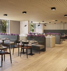 un restaurante con mesas, sillas y flores púrpuras en Hotel Principe Avila, en Lisboa