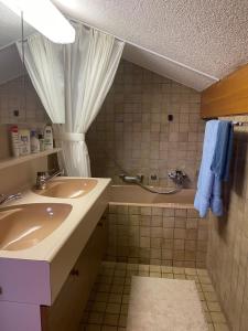 uma casa de banho com 2 lavatórios e um chuveiro com toalhas azuis em Penthouse - Ski-in Ski-out 30 meters from Medran lift and 40 meters from W Hotel em Verbier