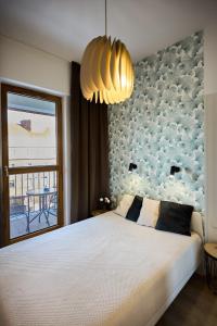 斯維諾烏伊希切的住宿－Golden Hour Apartments - Platan Tower，卧室设有一张白色大床和一扇窗户。