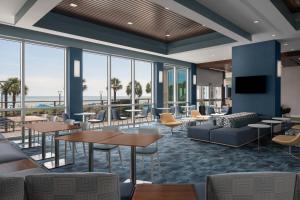 マートルビーチにあるSpringHill Suites by Marriott Myrtle Beach Oceanfrontのロビー(テーブル、椅子、窓付)