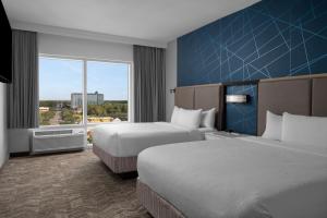 默特尔比奇SpringHill Suites by Marriott Myrtle Beach Oceanfront的有两张床和一扇大窗户的酒店房间