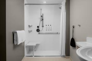 默特尔比奇SpringHill Suites by Marriott Myrtle Beach Oceanfront的带淋浴和水槽的白色浴室