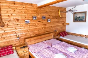 a room with a bed and a wooden wall at Chalupa u Žofky in Oščadnica