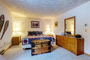 um quarto com uma cama com uma cómoda de madeira e um espelho em Christmas Mountain Adventures em Bartlett