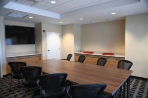 uma sala de conferências com uma mesa de madeira e cadeiras em TownePlace Suites Kansas City At Briarcliff em Kansas City