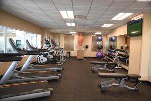 a gym with treadmills and elliptical machines at TownePlace Suites Kansas City At Briarcliff in Kansas City