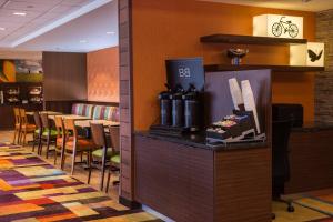 a restaurant with a bar with chairs and a table at Fairfield Inn & Suites by Marriott Olean in Olean