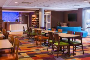 a dining room with tables and chairs in a library at Fairfield Inn & Suites by Marriott Olean in Olean