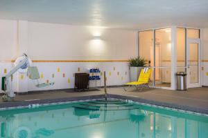 a swimming pool with a yellow chair next to it at Fairfield Inn & Suites by Marriott Olean in Olean