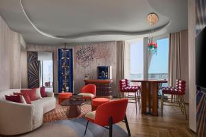 a living room with a white couch and red chairs at W Dubai - Mina Seyahi in Dubai
