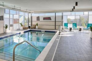 a pool in a building with blue chairs at Aloft Columbus in Columbus