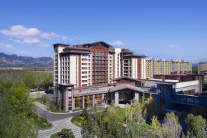 a large apartment building in a city with a street at Beijing Marriott Hotel Yanqing in Yanqing