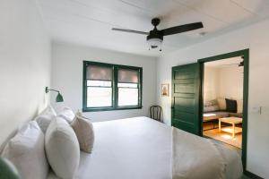 a bedroom with a white bed with a ceiling fan at Piety Hill Cottages in Nevada City