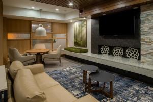 a living room with a couch and a tv at Fairfield Inn & Suites Houston Katy in Katy