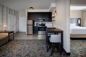 uma cozinha e sala de estar com uma cama e uma mesa em Residence Inn Waco South em Waco