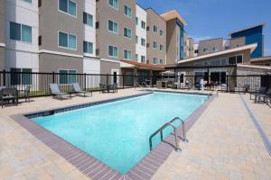 una piscina en un complejo de apartamentos con mesas y sillas en Residence Inn Waco South, en Waco