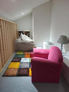 a living room with a pink couch and a colorful rug at La plage logement de tourisme meublé - 3 étoiles in Villers-sur-Mer